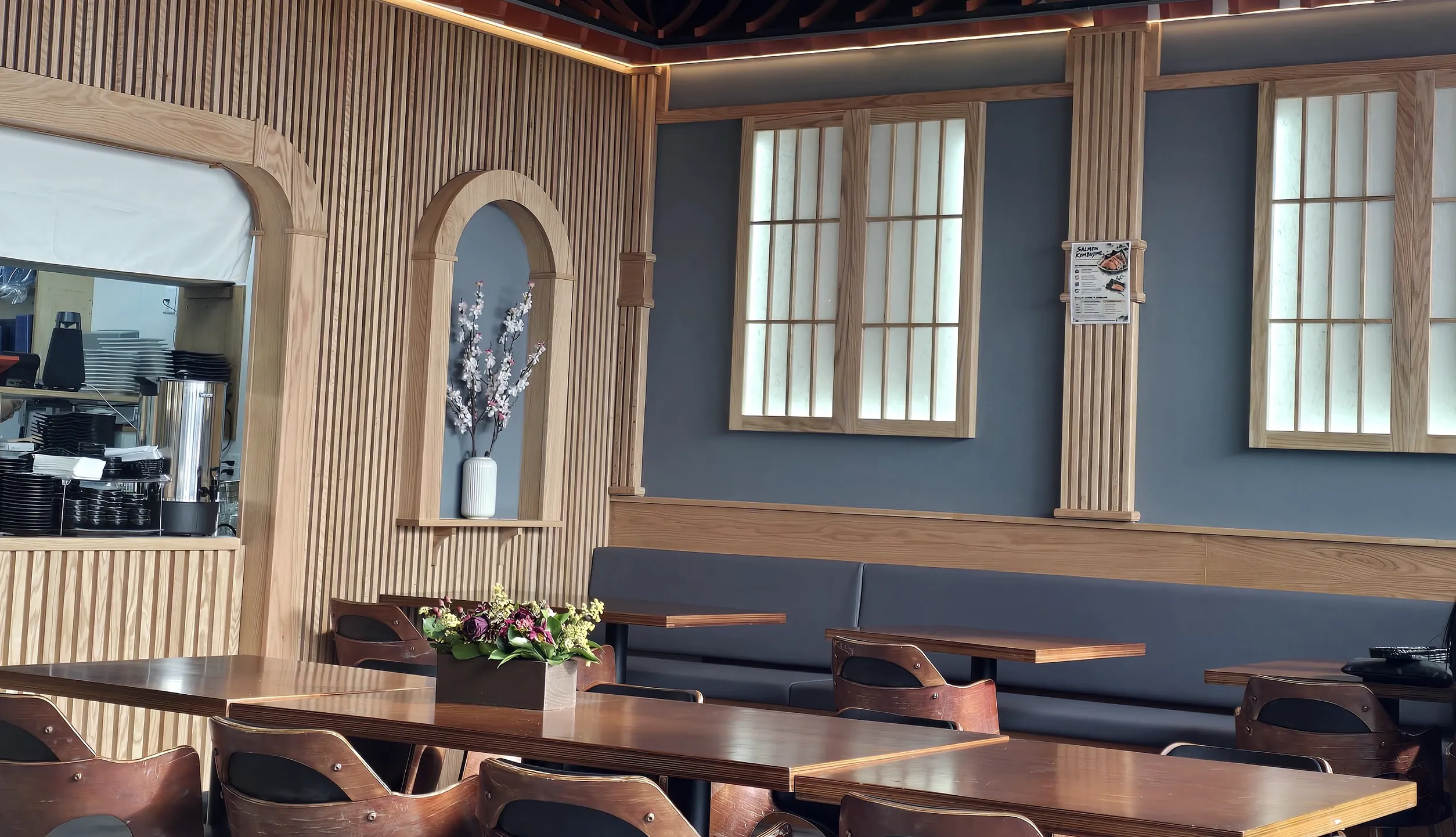 Rocky Maki dining room with wood-slat walls, shoji-style windows, pendant lights and wooden tables