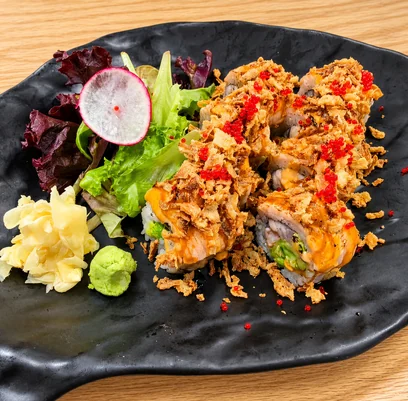 Double Salmon Roll with torched salmon, crispy onion and red tobiko, beside ginger, wasabi and salad